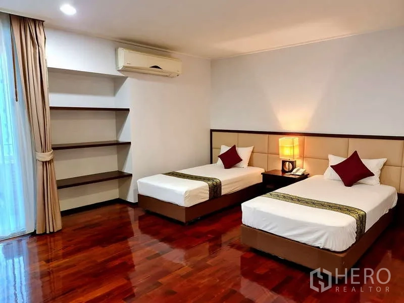 Apartment for rent - Spacious bedroom with twin beds, built-in shelves and polished wood floors.