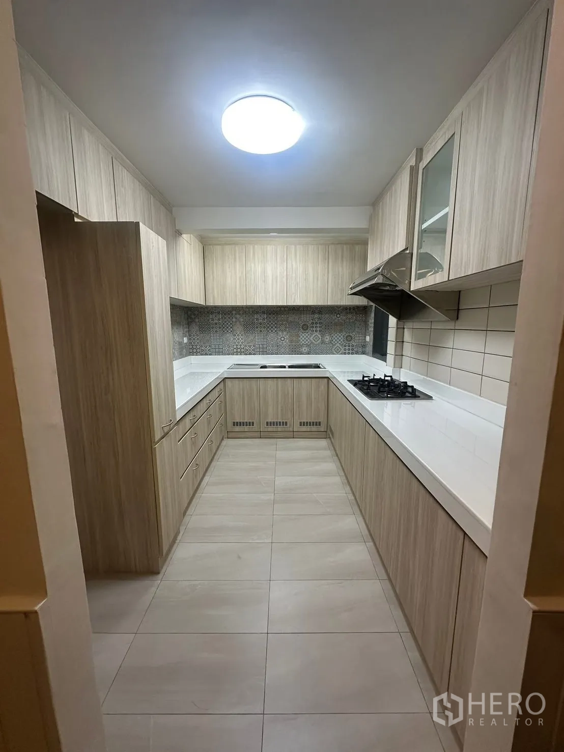 บ้าน for rent in Watthana, Bangkok - ครัวรูปตัวยู ตู้ไม้โทนอ่อน เตาแก๊ส เครื่องดูดควัน และพื้นที่เก็บของมากมาย
