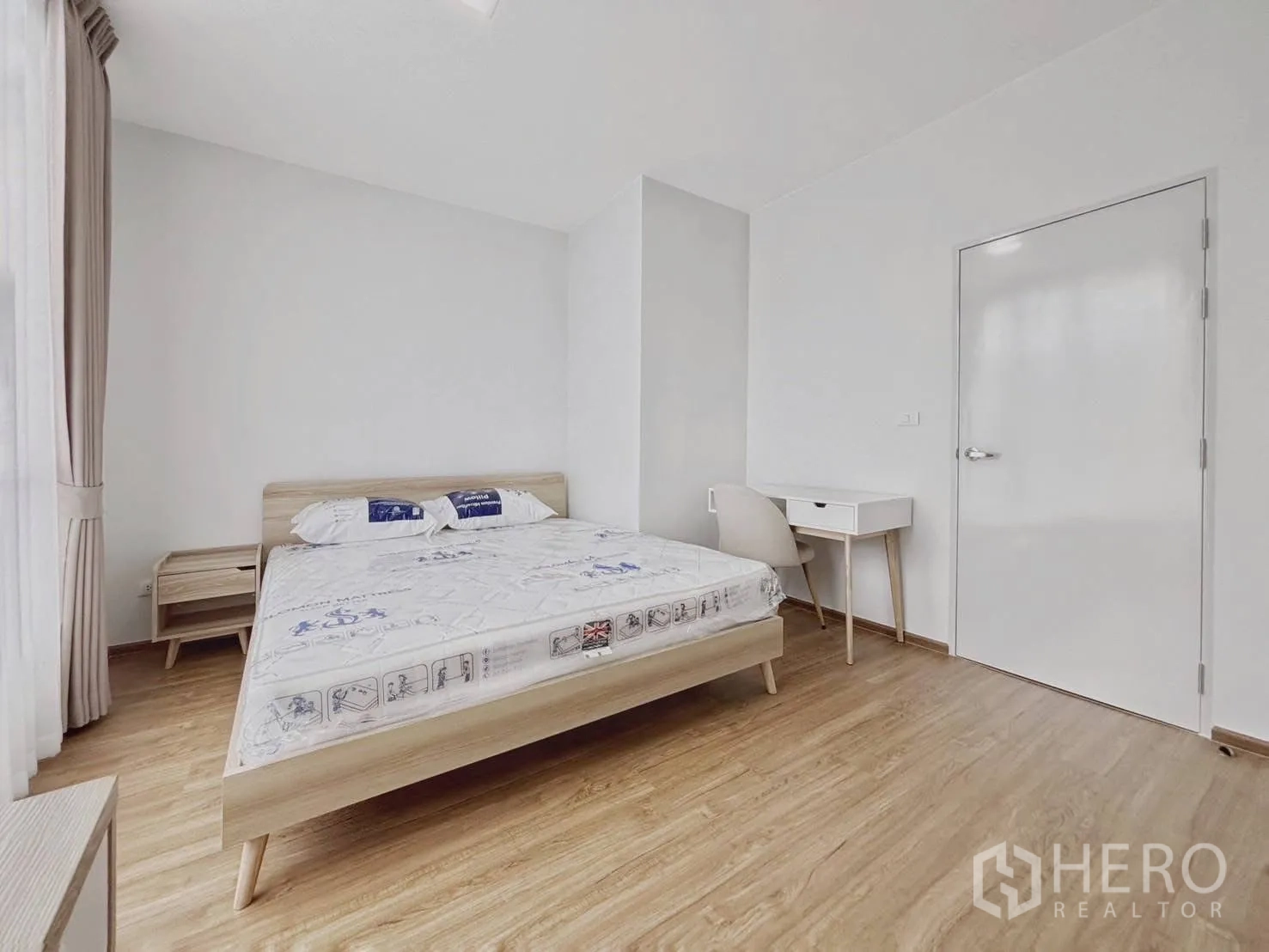Townhouse for rent in Bang Phli, Samut Prakan - Bedroom view with bed, side table, and compact work desk by the door.