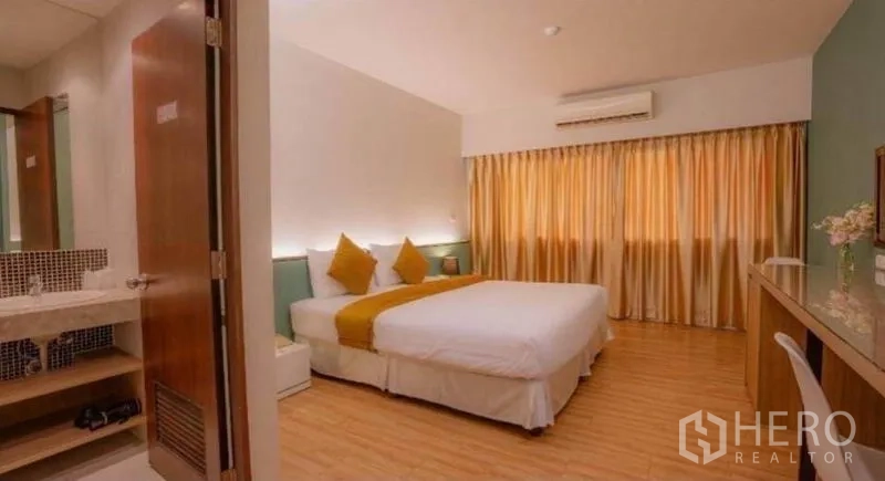 Retail Space for sale in Phra Nakhon, Bangkok - Ensuite bedroom with king bed, warm lighting, wood floors and bathroom entrance.
