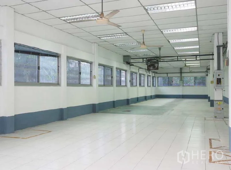 货栈 出租在Bang Kapi, Bangkok - 细长的瓷砖生产间，多扇窗户，格栅吊顶与吊扇通风。