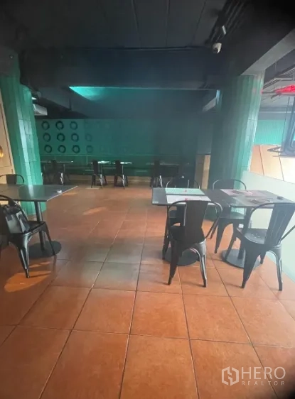 店屋 出租在Watthana, Bangkok - 宽敞的座位区，赤陶地砖与绿色立柱。