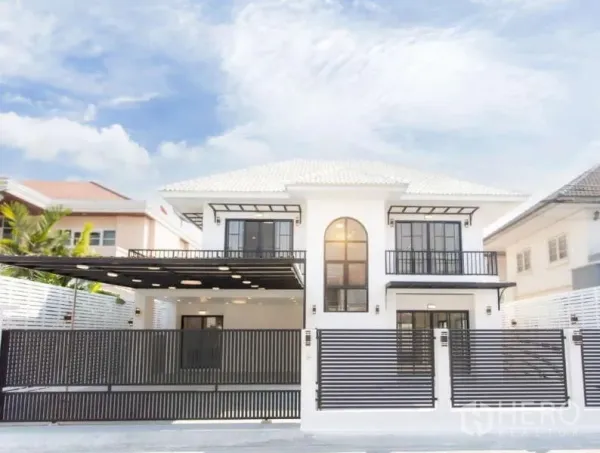 Detached House for sale in Wang Thonglang, Bangkok - Front exterior of a two-storey detached house with gated fence, balconies and covered carport.