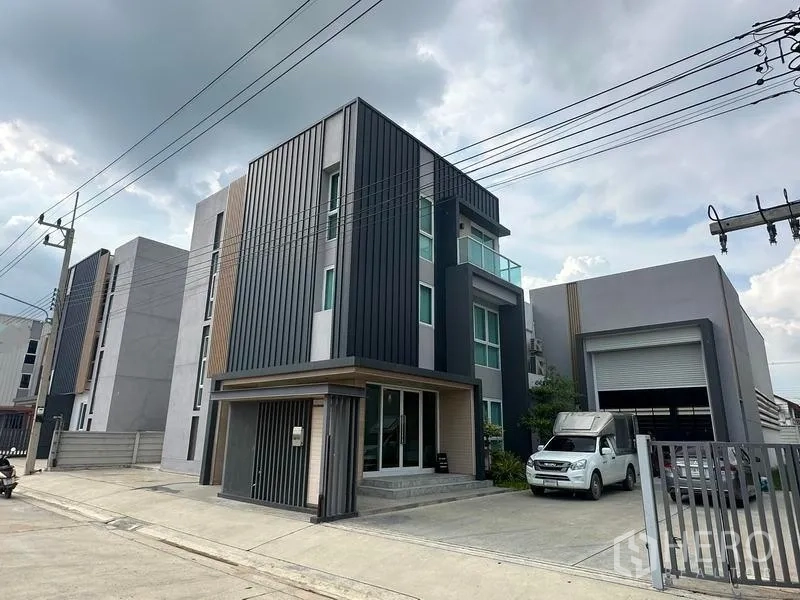 Warehouse for sale in Pathum Thani - Street view of the property showing the office block and adjacent warehouse with roller shutter.