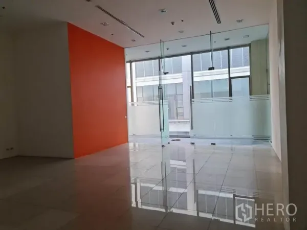 Retail Space for rent in Khlong Toei, Bangkok - Retail area facing full-height glass facade with frosted panels and orange wall.