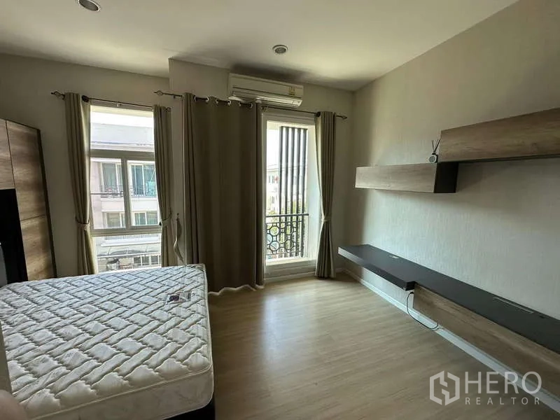 联排别墅 出租或出售在Wang Thonglang, Bangkok - 三层联排别墅外观，带有顶棚车位和金属大门，位于曼谷旺通郎。