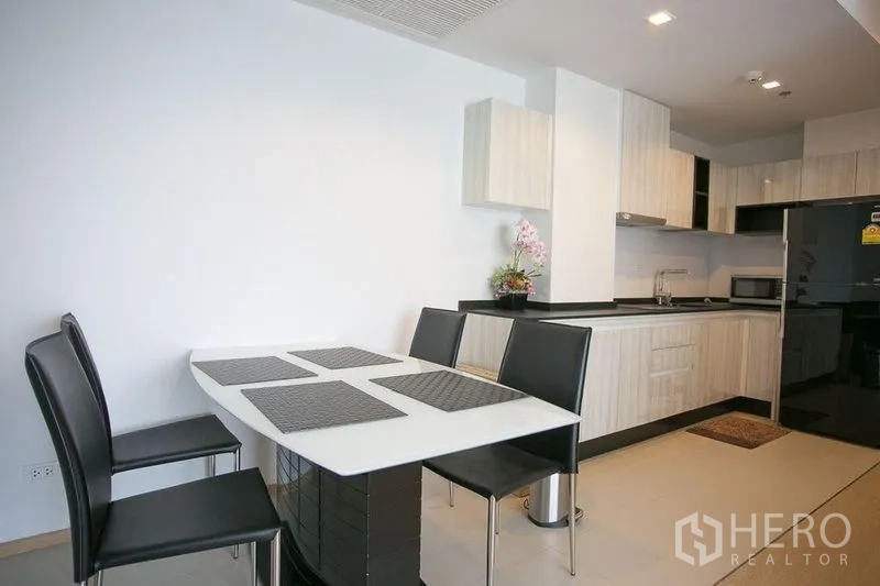 Condominium for rent in Watthana, Bangkok - Dining corner with four-seat table beside the open-plan kitchen.