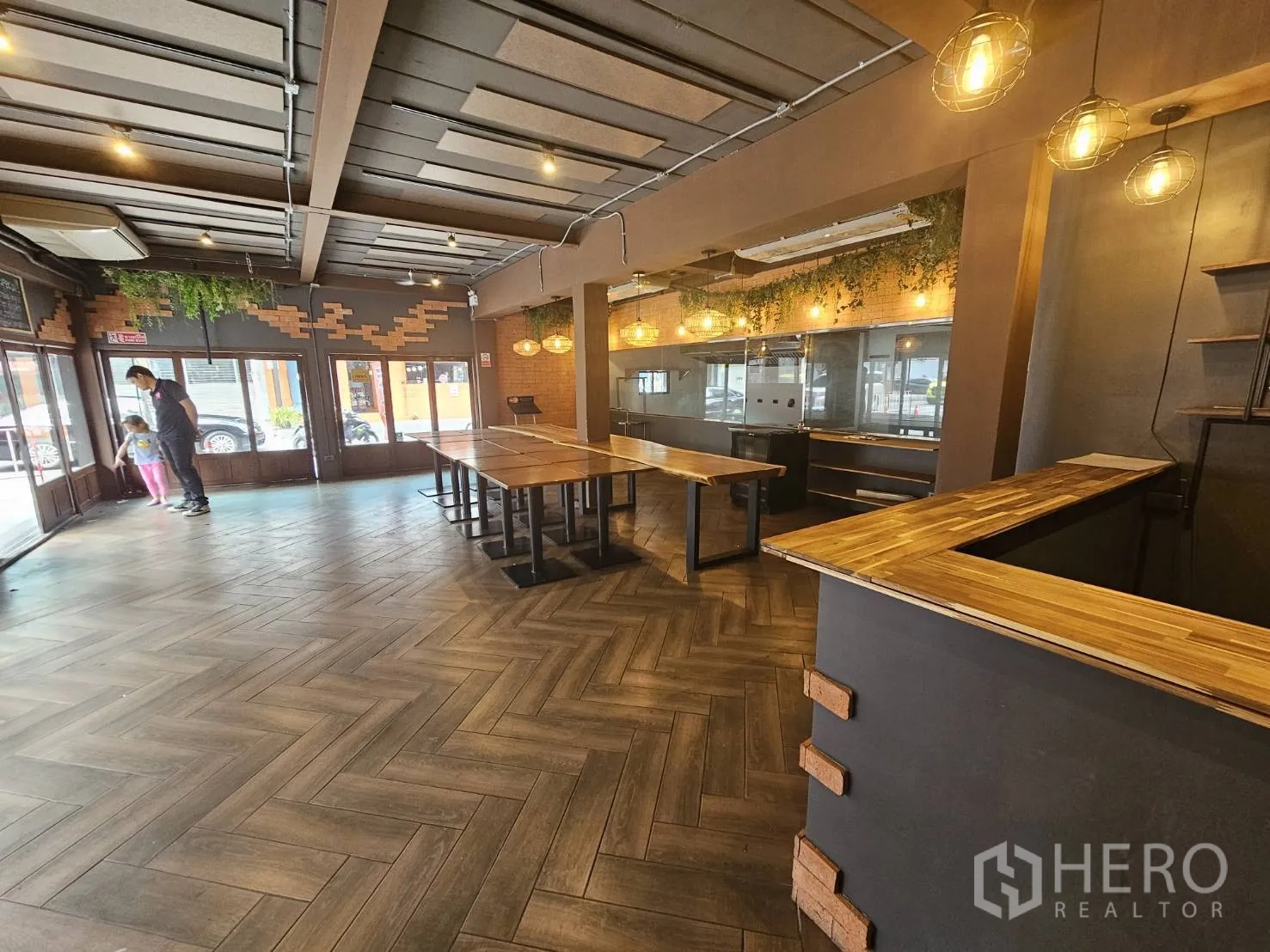 Retail Space for rent in Watthana, Bangkok - Spacious dining hall with herringbone wood floors, pendant lights, long tables and a glass shopfront.
