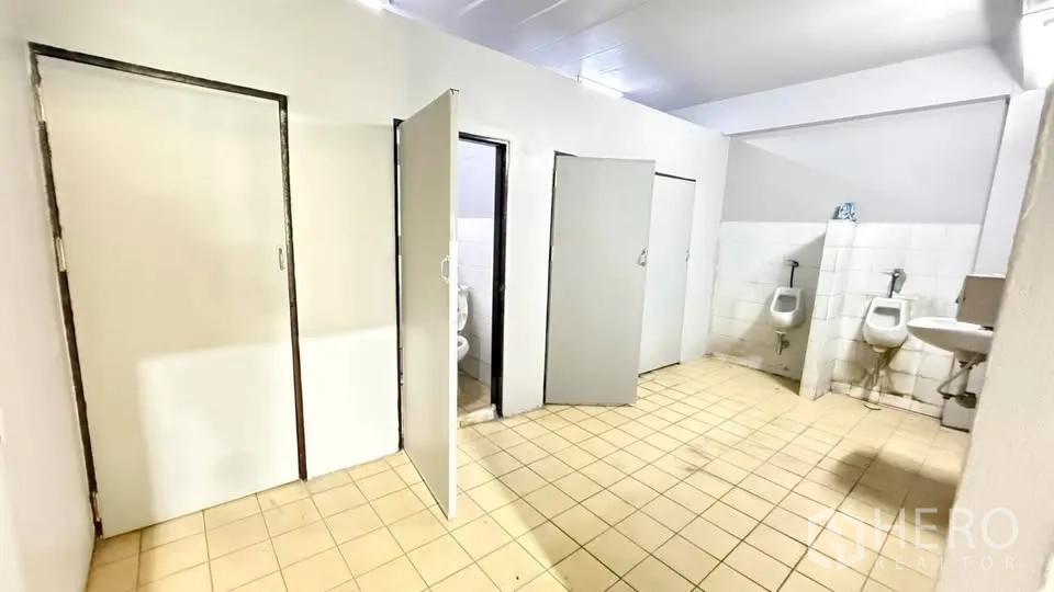 Warehouse for rent in Bang Na, Bangkok - Restroom area with toilet stalls, urinals and a sink.