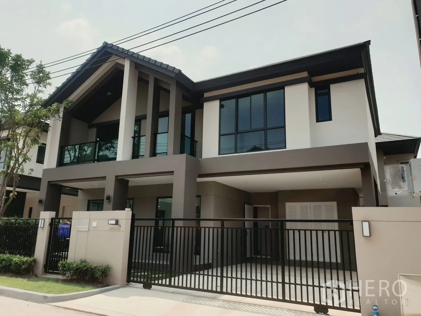 Detached House for rent in Saphan Sung, Bangkok - Contemporary two-storey detached house facade with gated carport and balcony.