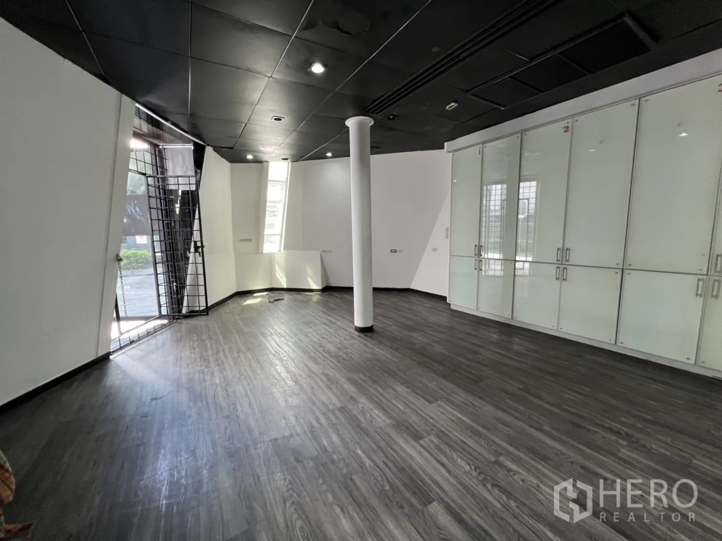 Retail Space for rent in Sathon, Bangkok - Ground-floor retail hall with glass cabinets, column and security gate to the outside.