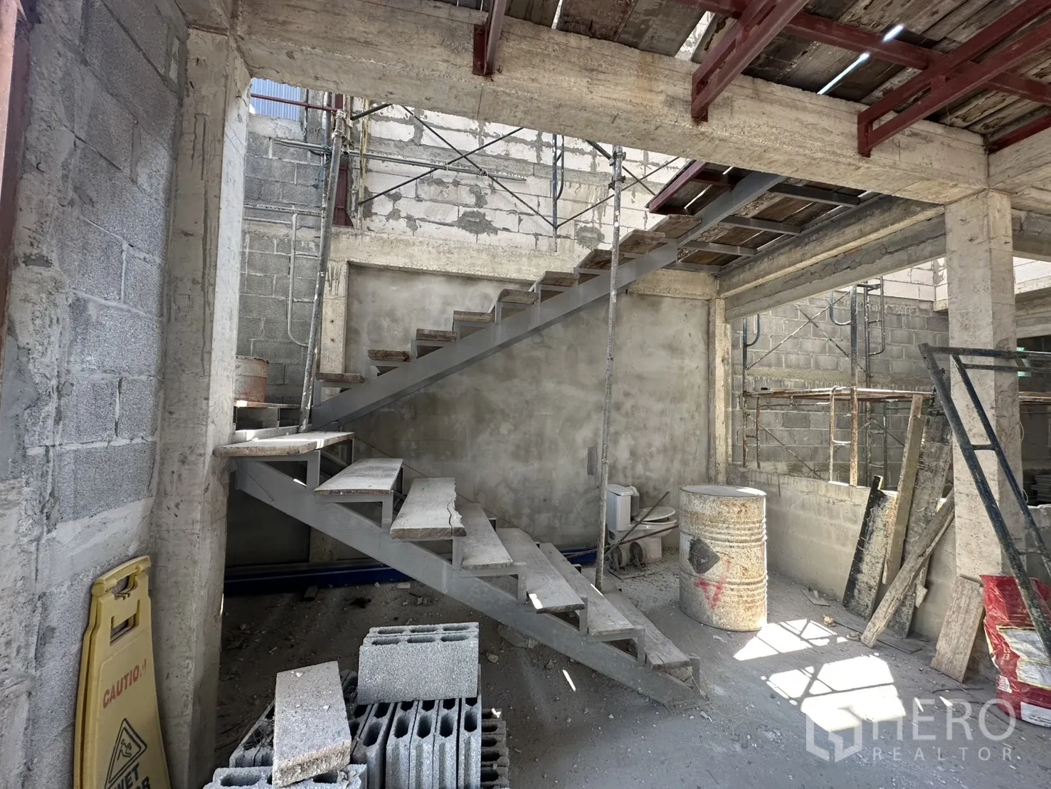 零售空间 for rent in Bang Na, Bangkok - 施工中的室内，金属楼梯骨架与毛坯混凝土墙。
