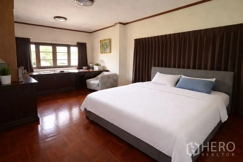 บ้านเดี่ยว for sale in Suan Luang, Bangkok - ห้องนอนขนาดใหญ่ เตียงคิงส์ไซส์ โต๊ะทำงานยาว และหน้าต่างบานกว้าง