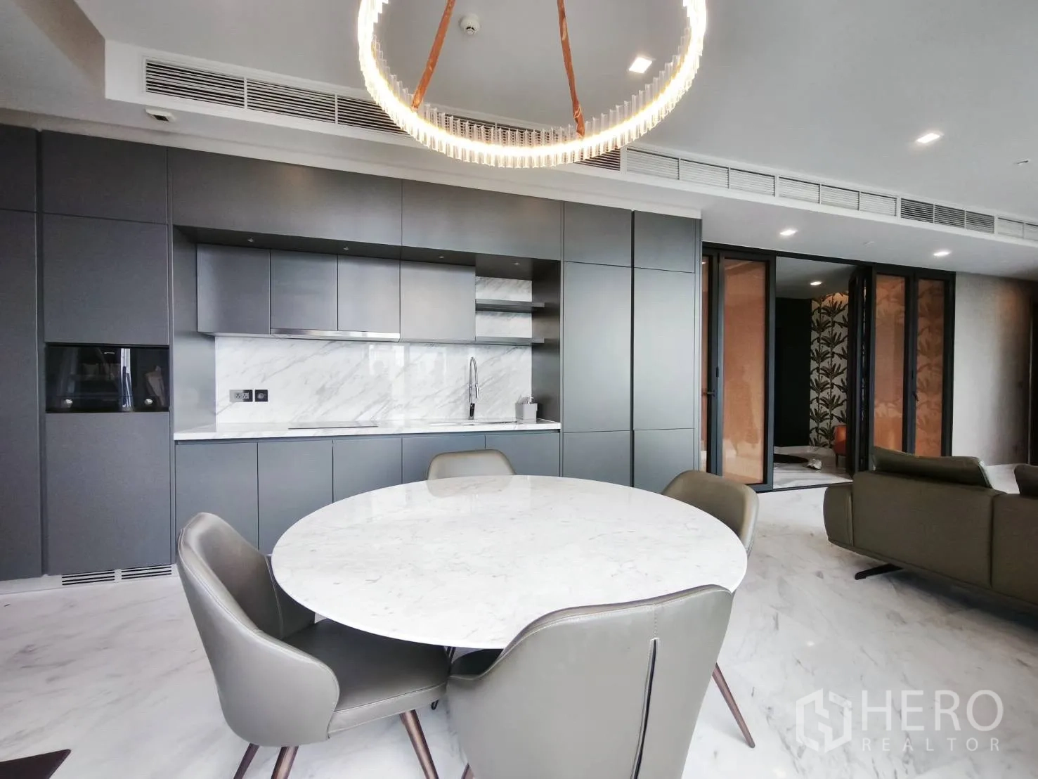 คอนโด for rent in Watthana, Bangkok - ครัวและพื้นที่ทานอาหารแบบเปิด พร้อมโต๊ะหินอ่อนทรงกลมและตู้สีเทา