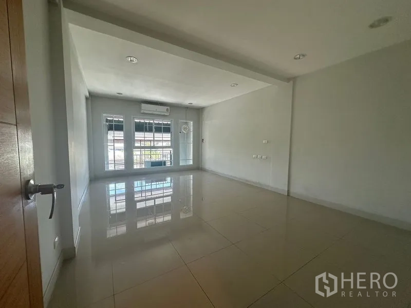 Home Office for rent in Bang Na, Bangkok - Bright rectangular room with front windows and AC on glossy tiled floor.