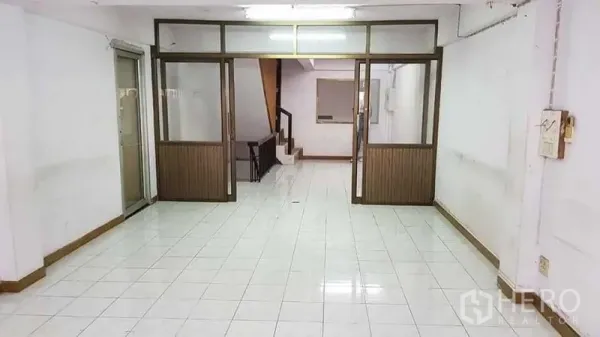 带办公室的家 出租或出售在Bang Na, Bangkok - 一层开放式空间，带玻璃隔断与室内楼梯。
