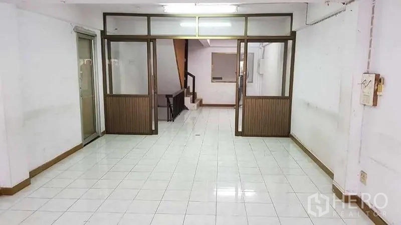带办公室的家 出租或出售在Bang Na, Bangkok - 一层开放式空间，带玻璃隔断与室内楼梯。