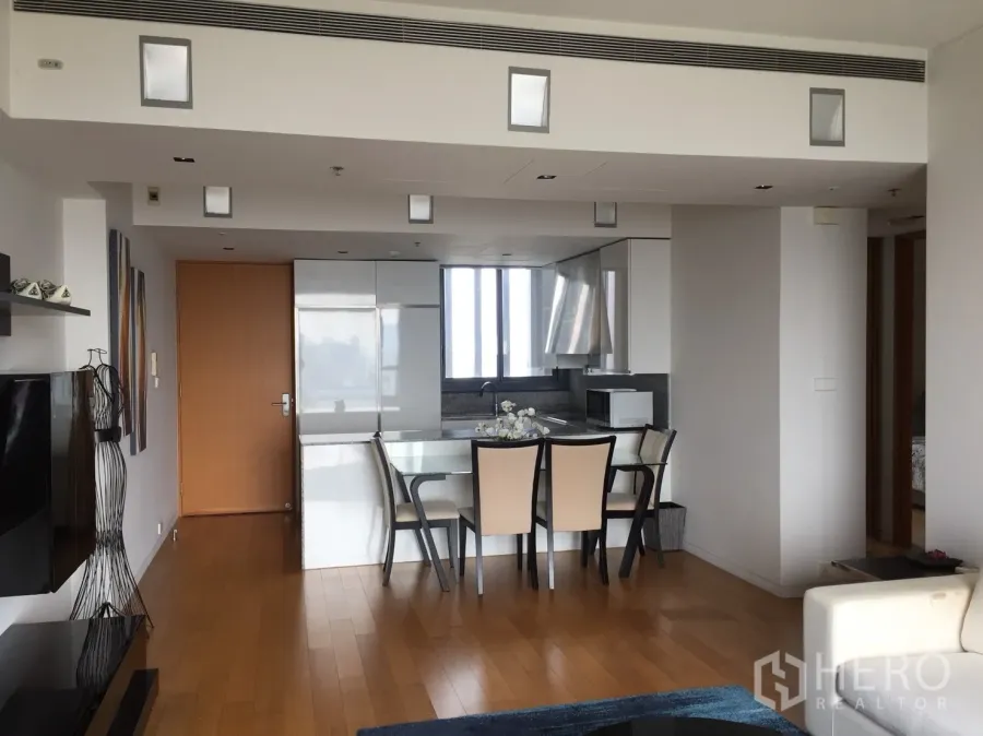 Condominium for rent or sale in Sathon, Bangkok - Open-plan living and dining area with hardwood floors and built-in storage.