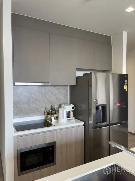 Condominium for rent in Bang Kho Laem, Bangkok - Compact kitchenette with stone backsplash, induction hob, and double-door fridge.
