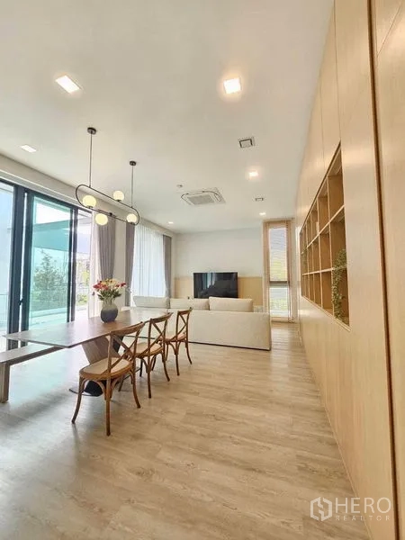 Detached House for rent - Open‑plan dining and living area with long wooden table and TV zone.