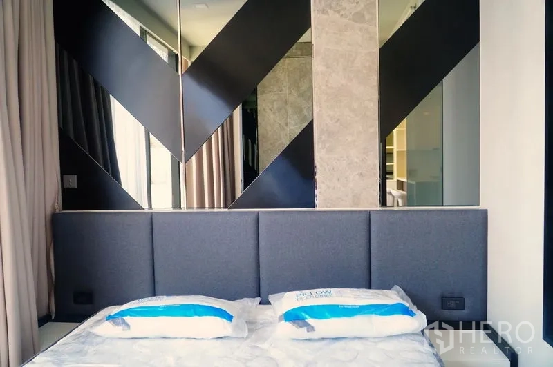คอนโด ให้เช่าในWatthana, Bangkok - ห้องนอนหัวเตียงบุผ้าและผนังกระจกลายเรขาคณิต