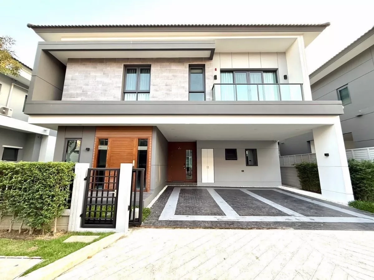 独立式住宅 出租在Bang Phli, Samut Prakan - 邦普里现代两层独栋别墅外观，带遮蔽三车位、玻璃阳台与整齐绿篱。