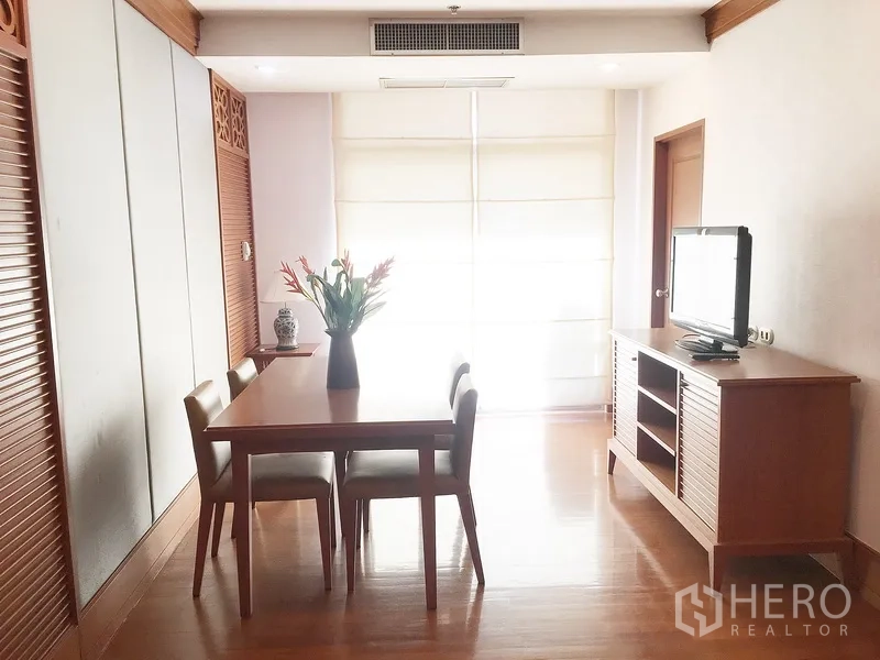 公寓 出租在Pathum Wan, Bangkok - 明亮的用餐区，木质餐桌四椅、电视柜与大幅窗帘。