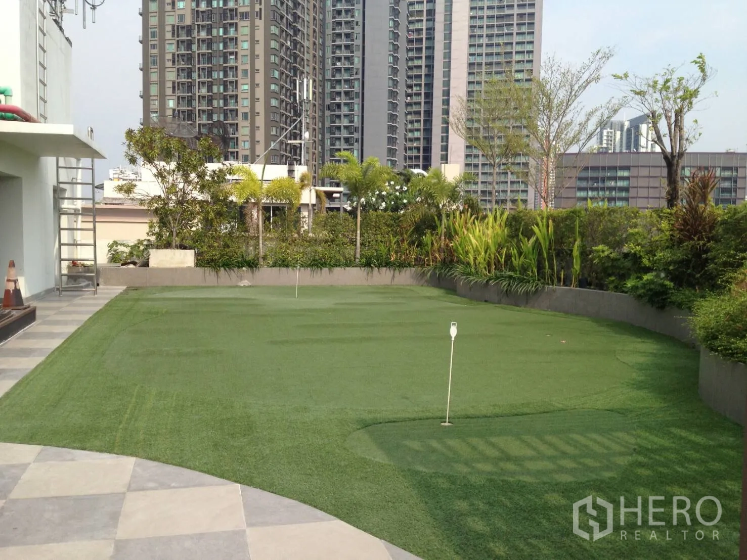 Condominium for rent in Khlong Toei, Bangkok - Rooftop putting green with lush garden and city high-rises at Tidy Deluxe near Thonglor.