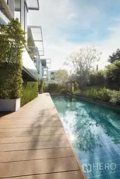 Townhouse for rent in Huai Khwang, Bangkok - Lap pool with timber deck beside landscaped hedges at a modern townhouse community in Huai Khwang.