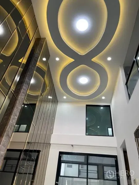 Townhouse for rent or sale in Yan Nawa, Bangkok - Close view of oval LED ceiling design above the mezzanine windows in the tall living space.