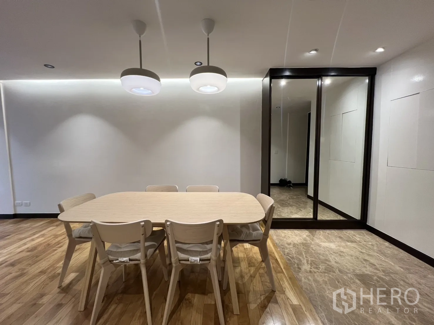 อพาร์ทเมนท์ for rent in Watthana, Bangkok - โต๊ะอาหาร 6 ที่นั่งใต้โคมแขวนคู่ ข้างผนังบานตู้กระจกเงาและพื้นหินอ่อนบริเวณทางเข้า