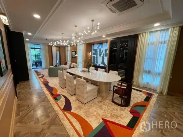Detached House for rent or sale in Saphan Sung, Bangkok - Elegant formal dining room with oval table, glass chandeliers and a colorful patterned area rug.