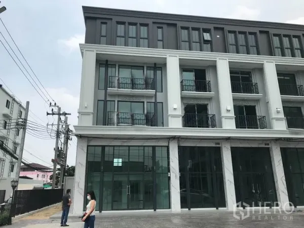 Home Office for rent in Suan Luang, Bangkok - Modern four-storey home office facade with floor-to-ceiling glass, balconies and a paved parking forecourt in Suan Luang, Bangkok.