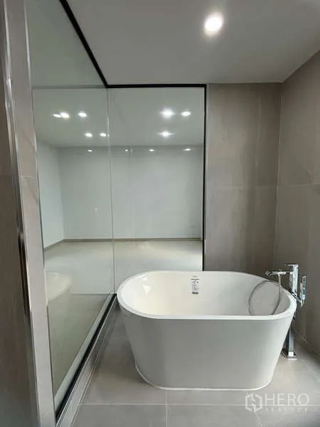 独立式住宅 出租或出售在Suan Luang, Bangkok - 中性色调浴室内的独立式浴缸，旁接落地玻璃隔断