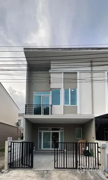 联排别墅 出租在Bang Phli, Samut Prakan - 房屋正立面，带车道大门和有顶停车位