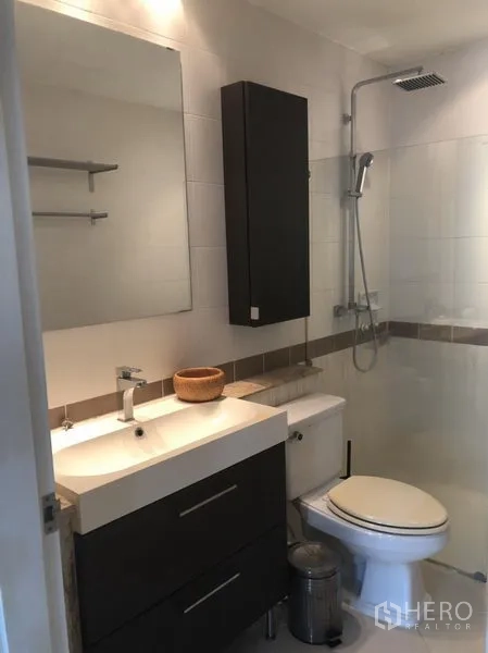 Townhouse for rent in Bang Kapi, Bangkok - Contemporary bathroom with vanity, toilet and a glass-enclosed rain shower.
