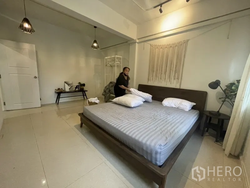 Home Office for rent or sale in Watthana, Bangkok - Large bedroom with king-size bed, pendant lights and minimalist decor.