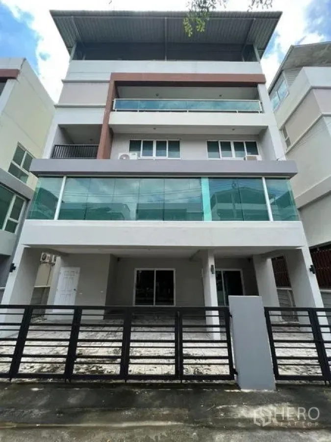 Home Office for rent or sale in Bang Phli, Samut Prakan - Front elevation of four-level home office with balconies and driveway gate.