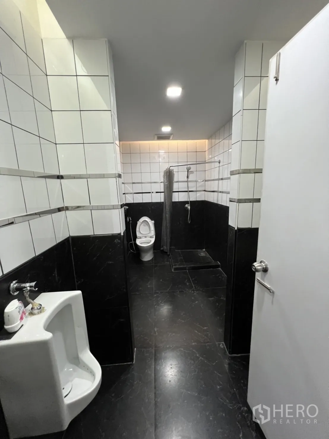 Retail Space for rent in Sathon, Bangkok - Restroom with urinal, toilet and separate shower zone in black-and-white tiles.