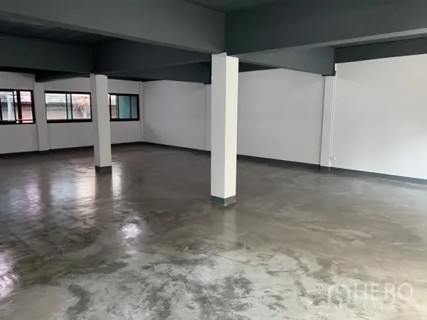 Shophouse for rent in Khlong Toei, Bangkok - Clean renovated interior with multiple columns, neutral tones and side windows for cross ventilation.
