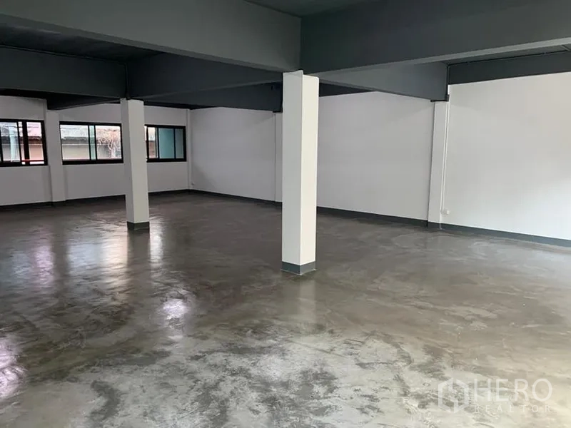 Shophouse for rent in Khlong Toei, Bangkok - Clean renovated interior with multiple columns, neutral tones and side windows for cross ventilation.