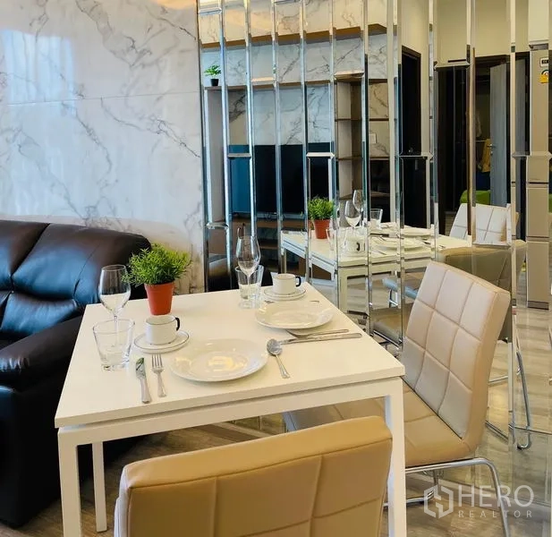 Condominium for rent in Bang Na, Bangkok - Cozy dining nook beside a mirrored feature wall and marble accents in the living area.
