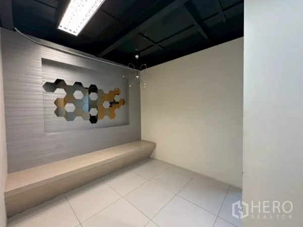 办公空间 出租在Khlong Toei, Bangkok - 接待角落，内置长椅与蜂窝造型墙面装饰。