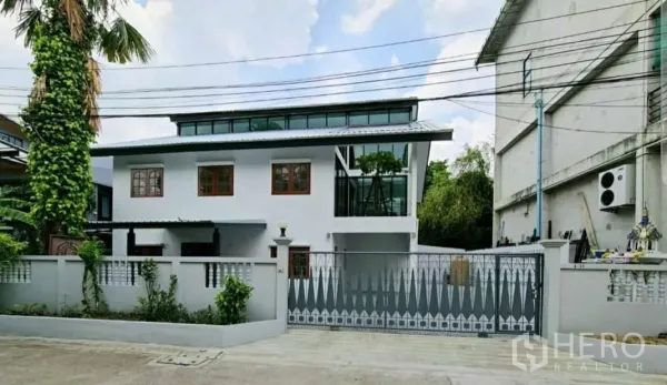 带办公室的家 出租在Lat Phrao, Bangkok - 翻新两层家庭办公楼，白色外立面、天窗带来的高侧窗与金属推拉大门，位于安静小巷。