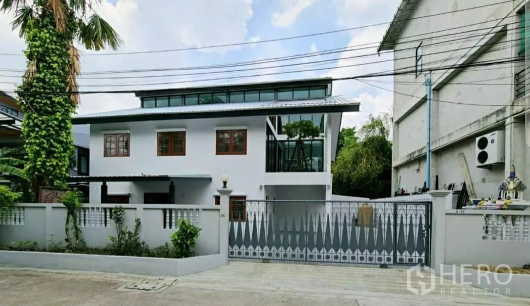 带办公室的家 出租在Lat Phrao, Bangkok - 翻新两层家庭办公楼，白色外立面、天窗带来的高侧窗与金属推拉大门，位于安静小巷。
