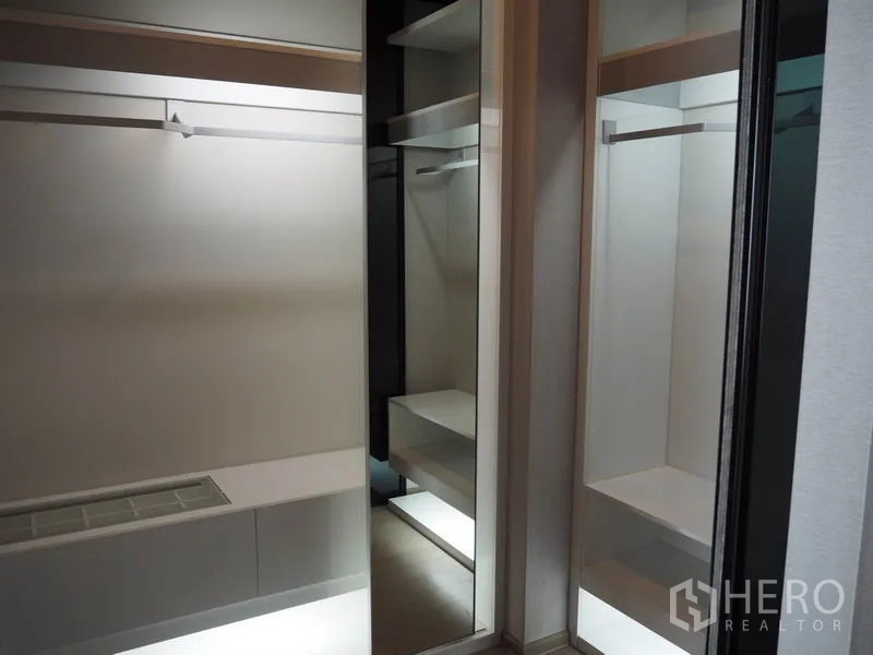 公寓 出租在Ratchathewi, Bangkok - 步入式衣帽间，镜面移门、挂衣杆与带灯置物层板。