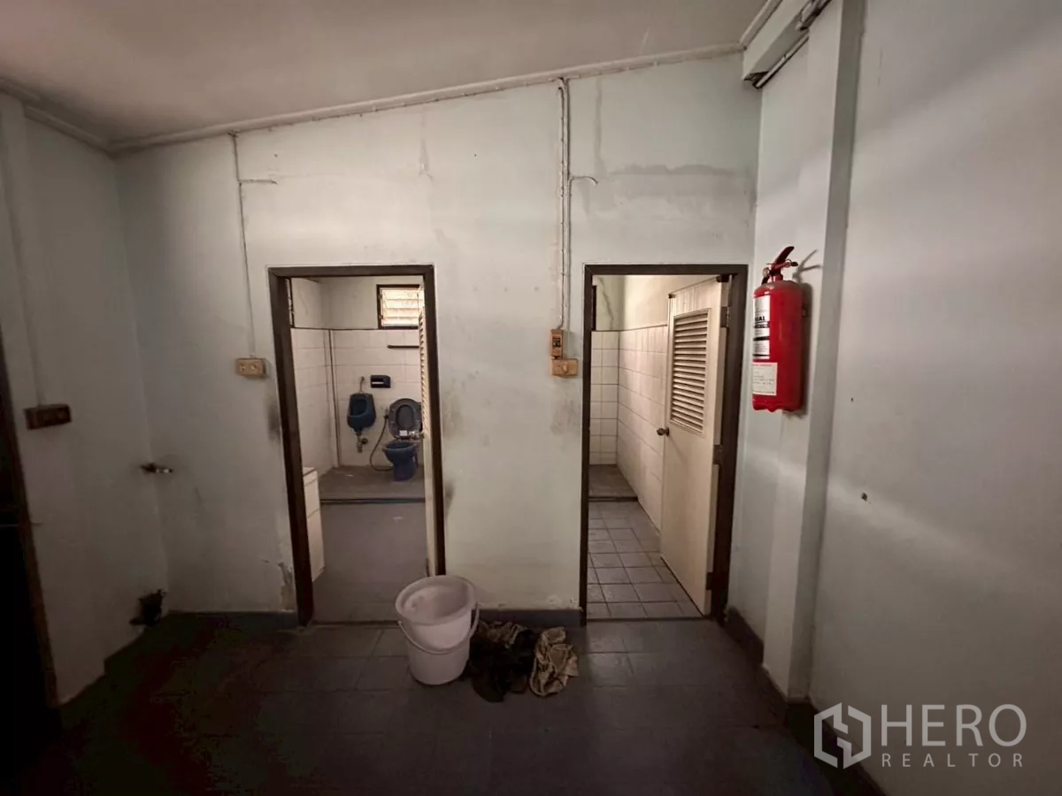 零售空间 出租在Khlong Toei, Bangkok - 瓷砖卫生间区域，分隔间并有壁挂灭火器