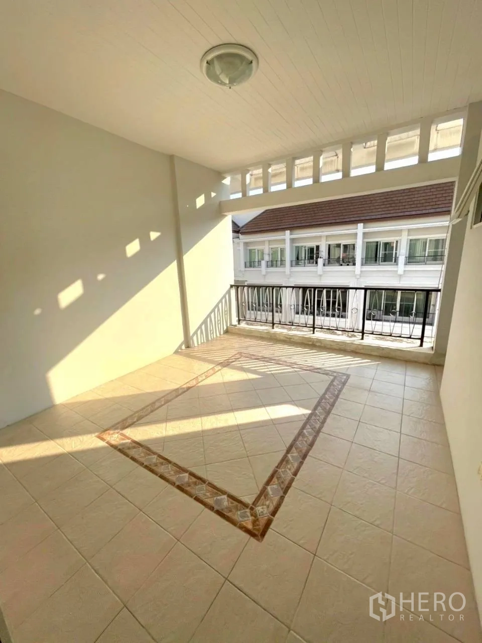 Townhouse for rent in Bang Kho Laem, Bangkok - Covered balcony or terrace with tiled floor and railing overlooking neighboring homes.