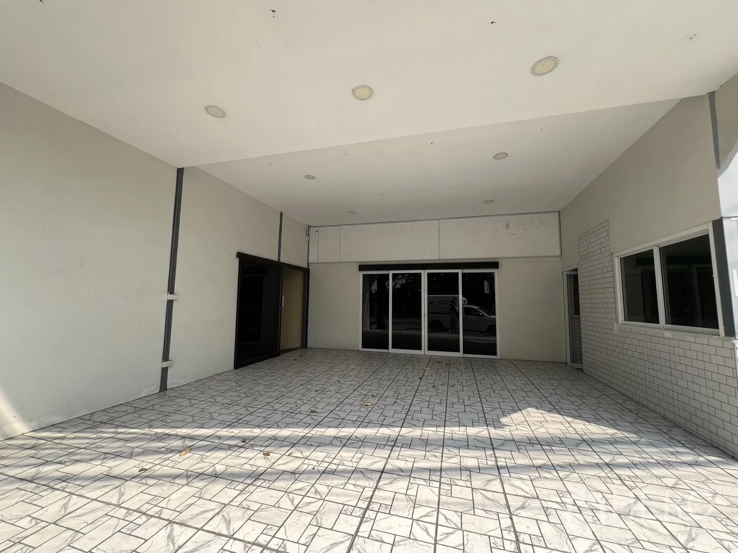 零售空间 for rent in Bueng Kum, Bangkok - 带屋檐的前廊，通向推拉玻璃门，地面为瓷砖并有嵌灯。