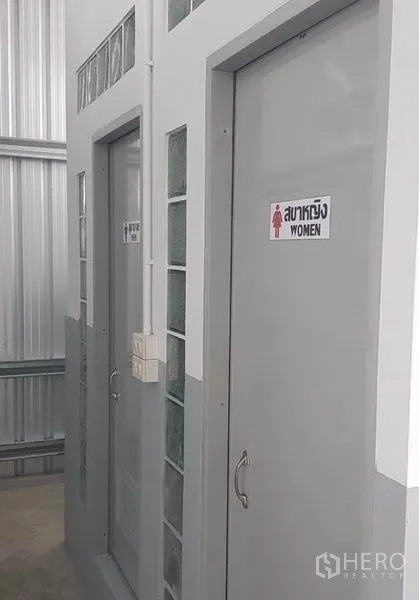 Warehouse for rent in Mueang Nonthaburi, Nonthaburi - Clean restroom entrance with labeled doors inside the warehouse.